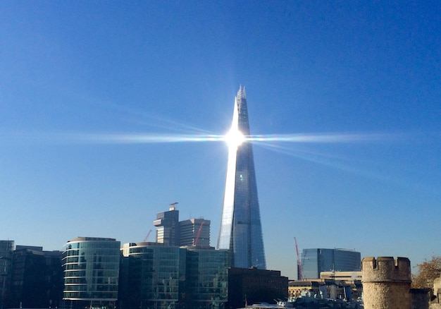 写真 晴れた空に照らされた街のシャード・ロンドン・ブリッジを通って放出される太陽の光