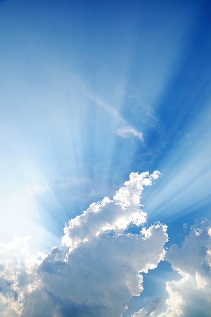 Sunbeam through the haze on blue sky, clouds with sun rays