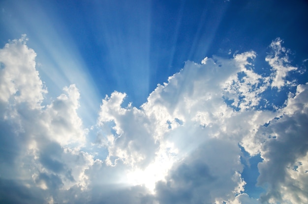 Sunbeam through the haze on blue sky, clouds with sun rays