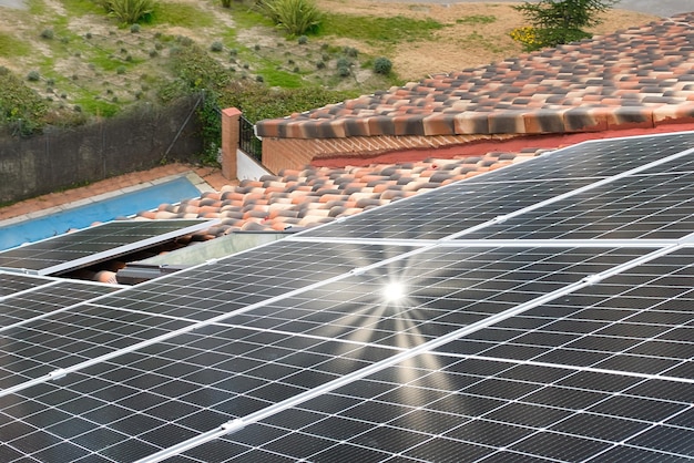 Sunbeams reflected in solar panels on a roof.