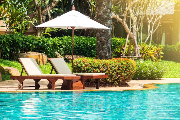Foto lettino con ombrellone a bordo piscina. struttura rilassante