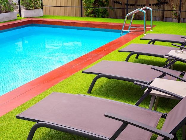 Foto lettini sull'erba verde sulla piscina all'aperto