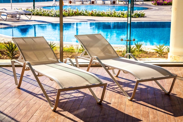 Sunbeds in the indoor swimming pool with views of the outdoor pool