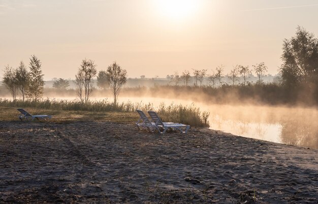 Sunbeds on the shore of the morning lake