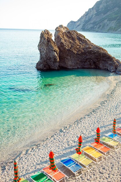 Sunbeds and umbrellas at beautiful european seashore in Monterosso in Italy, Cinque Terre, Liguria