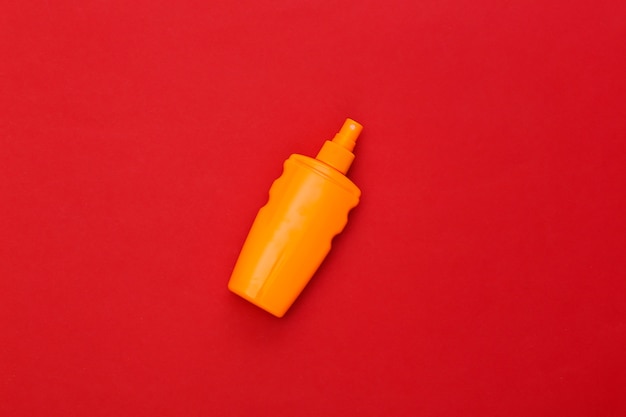 Sunblock bottle on red bright. Skin protection. Beach vacation.