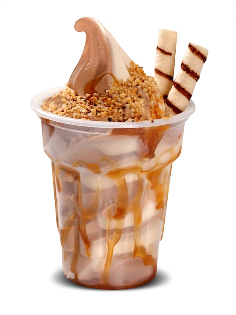 白い背景の上にカップのキャラメルシロップとサンデーアイスクリーム。アイスクリーム。