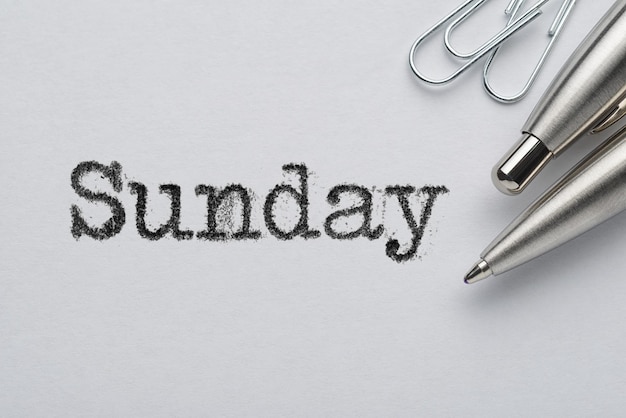 Sunday word printed with typewriter pen and paper clips