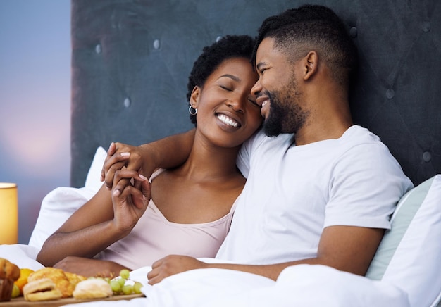 Sundays in bed are such a treat Shot of a happy young couple enjoying breakfast in bed together at home