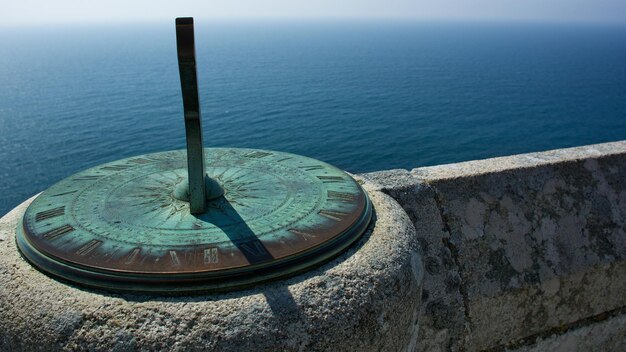 Foto orologio solare a parete di sostegno sul mare