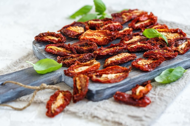 Sundried tomatoes and green basil leaves