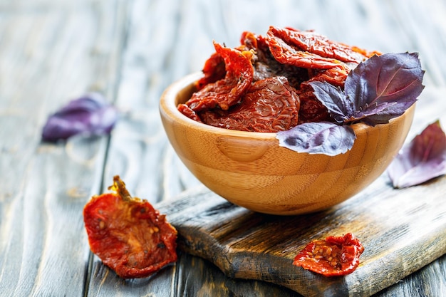 Sundried tomatoes and purple basil in a wooden bowl