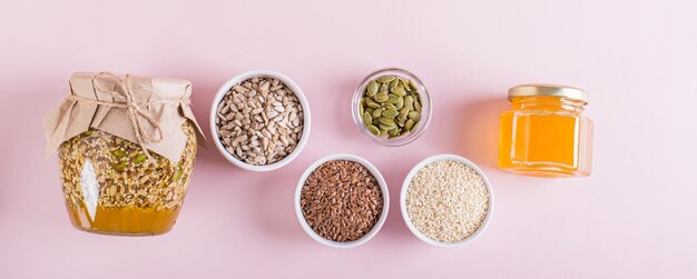 Photo sunflower flax sesame pumpkin seeds and honey for a healthy immune blend top view web banner