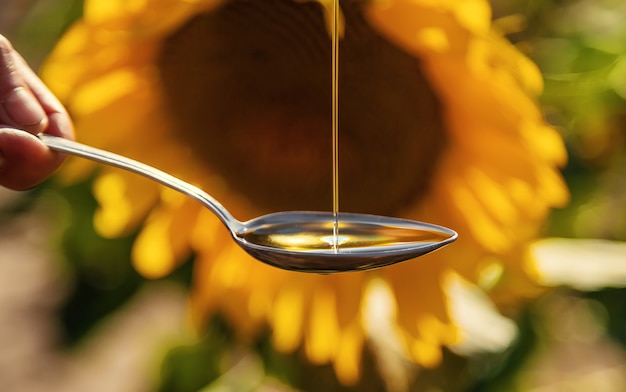 Sunflower oil in a spoon on the field. Selective focus. Nature.