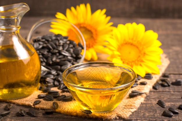 Sunflower oil and sunflower seeds on traditional rustic wooden background. Organic and eco food conc