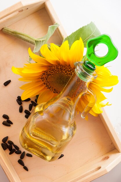 Sunflower oil in a transparent jug with sunflower flower
