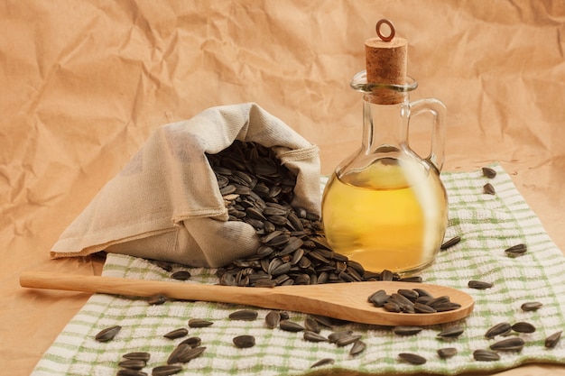 Sunflower oil with a bag of seeds and a wooden spoon