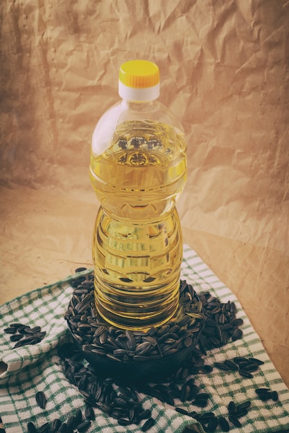 Photo sunflower oil with a bag of seeds and a wooden spoon