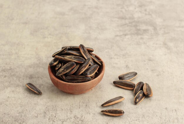 Sunflower Seed on Small Wooden Bowl Isolated on Rustic Brown Background