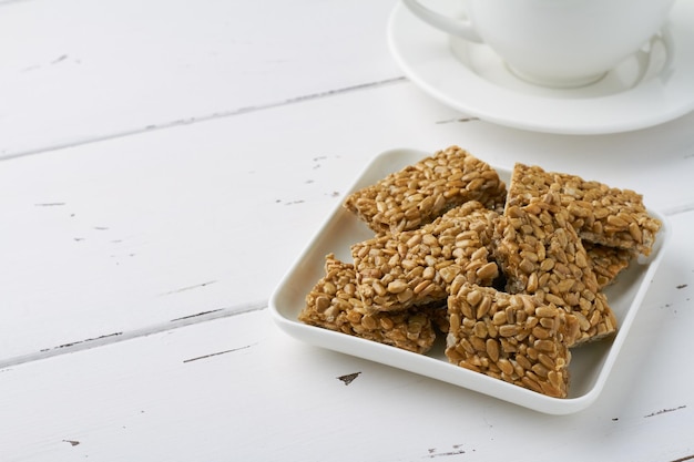 Photo sunflower seeds brittle white plate georgian oriental sweetnes kozinaki gozinaki white background