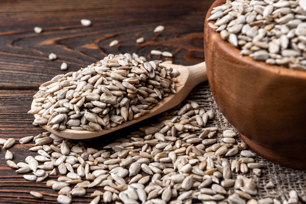 Sunflower seeds on dark wooden background.