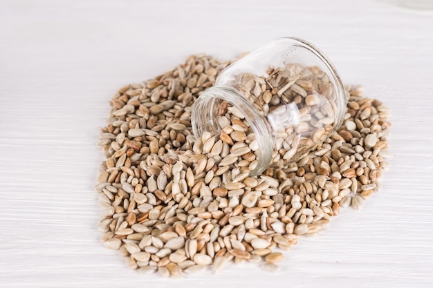 Sunflower seeds in a jar  on white wooden background. vegetarian food, eco food concepts