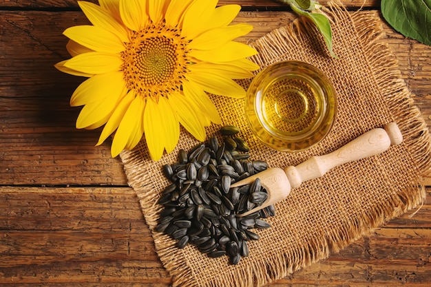 Sunflower seeds and oil bottle on old wooden background. Selective focus.nature