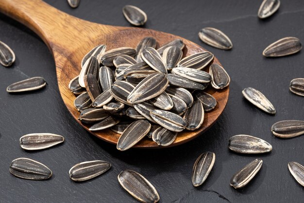 Sunflower Seeds in spoon on black slate. Helianthus seed