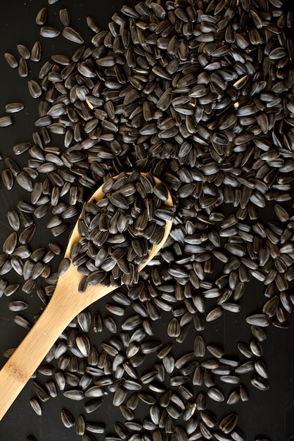 Sunflower seeds on wooden background, top view, copy space