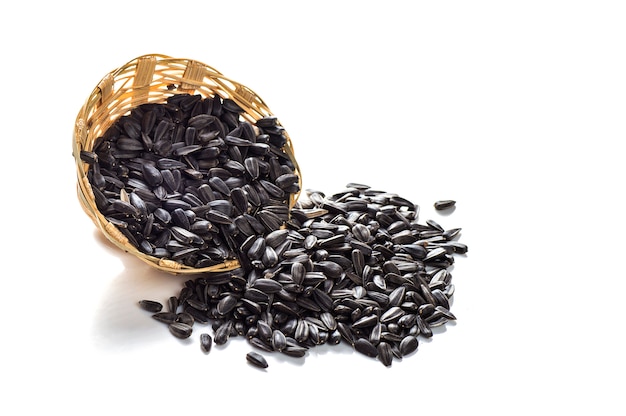 Sunflower Seeds in wooden basket on white background. Helianthus annuus.