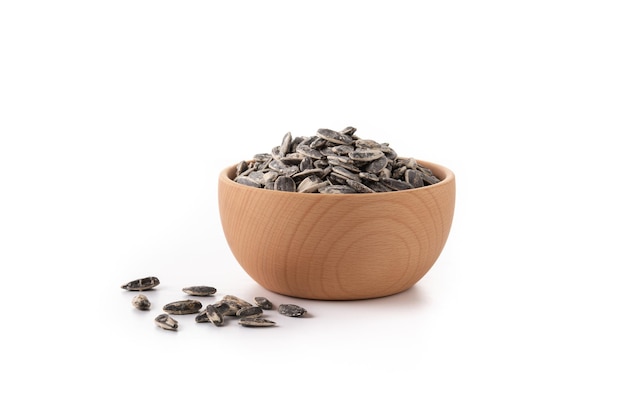 Sunflower seeds in wooden bowl isolated on white background