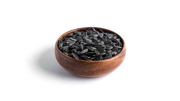 Sunflower seeds in a wooden bowl isolated.