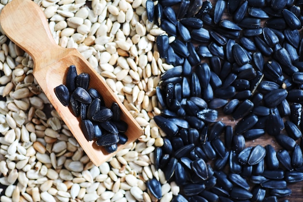 Sunflower seeds in a wooden spoon on a wooden rustic background.