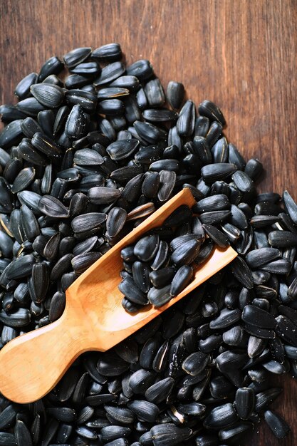 Sunflower seeds in a wooden spoon on a wooden rustic background.