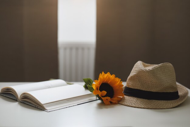  sunflower and a straw hat and a book 