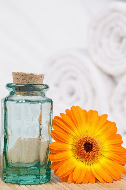 Sunflower with a glass phial and white towels