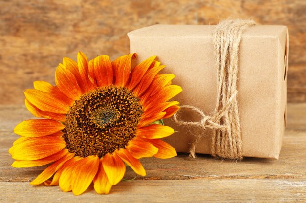 Photo sunflowers with present box on wooden background