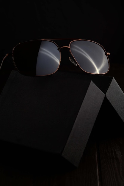 Photo sunglass on brown textured wood table with dark background