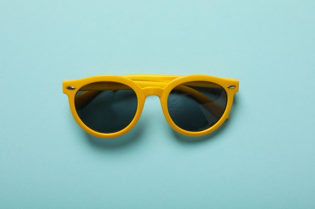 Sunglasses on a blue background top view