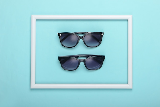 Sunglasses on blue surface with white frame