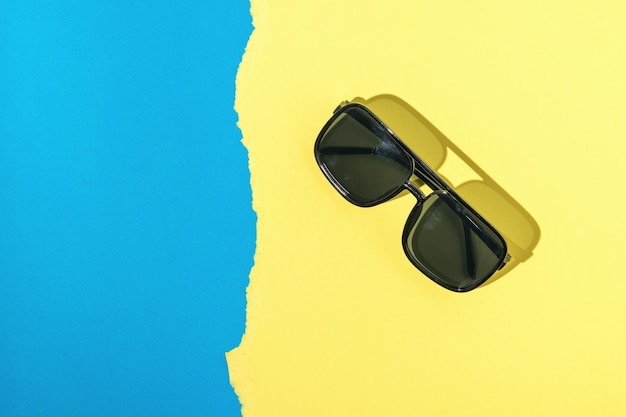 Sunglasses in bright light on a blue and yellow background