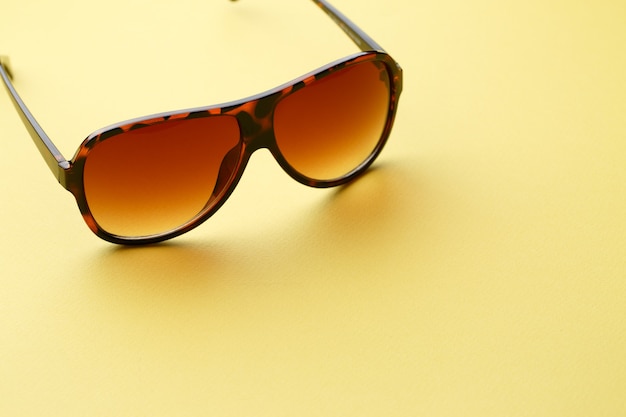 Sunglasses in empty yellow background