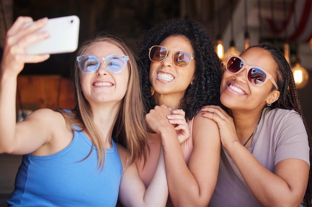 Photo sunglasses friends and selfie with women in restaurant for social media freedom and support happy diversity and photo with group of girls in cafe for picture networking and relax on weekend