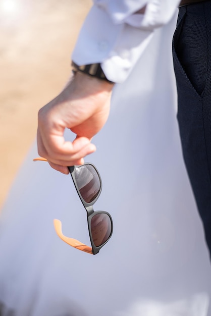 Sunglasses in the hands of a man summer style purchase plan