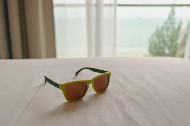 사진 여행 및 휴가 개념에서 호텔의 침대에 남겨진 선글라스