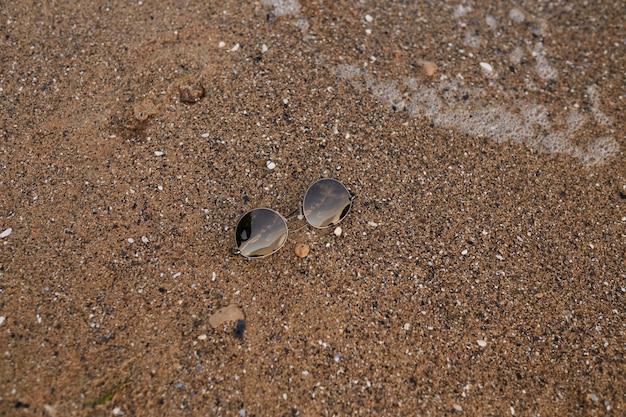 Sunglasses lie on the sand