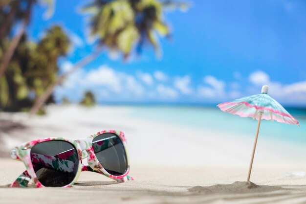 Sunglasses lying on tropical sand beach