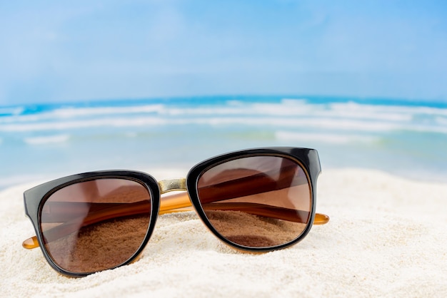 Occhiali da sole sulla sabbia in spiaggia