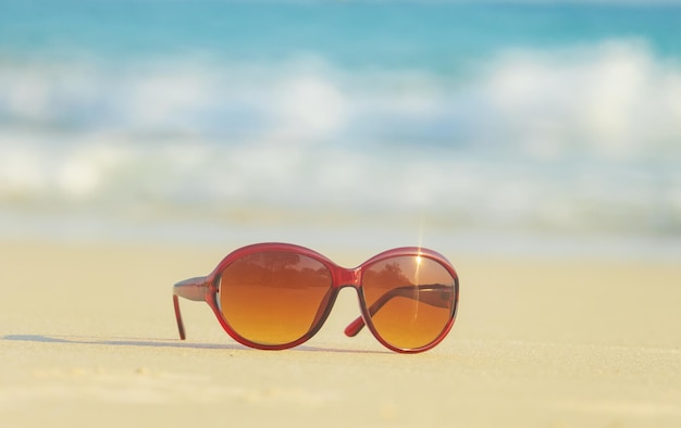 Occhiali da sole sulla sabbia bellissima spiaggia estiva