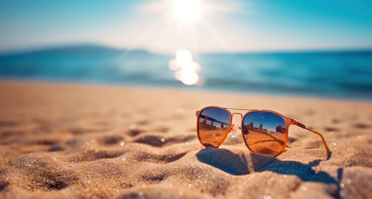 Photo sunglasses on sand at summer beach with sunshine holiday vacation background